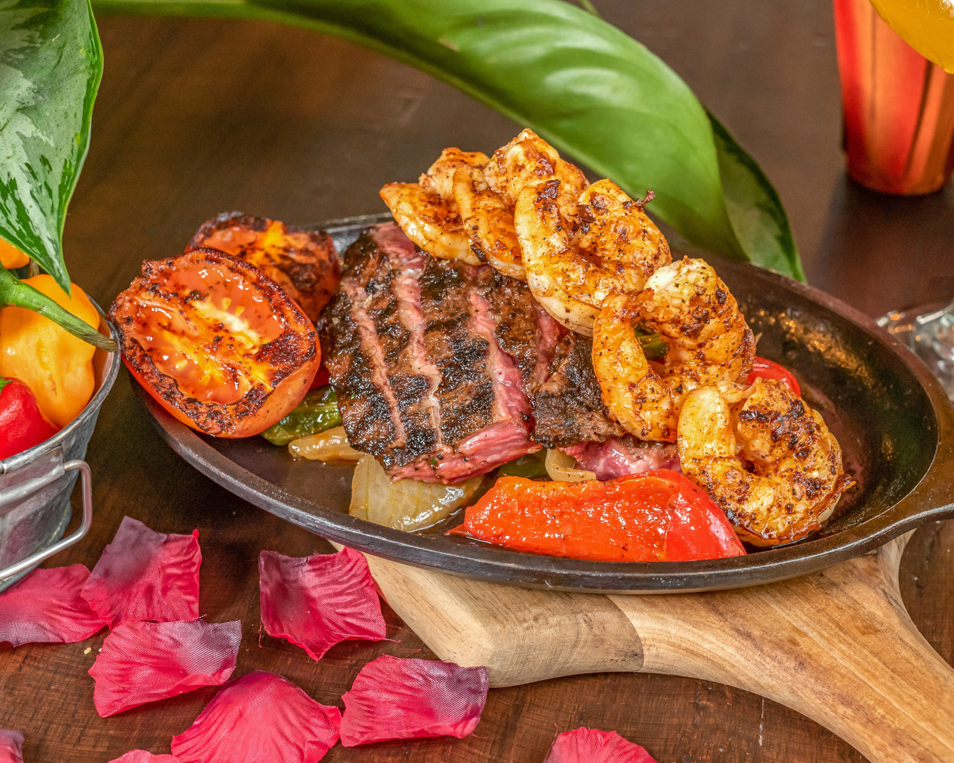 Grilled steak and shrimp combo plate with rice, beans and fresh toppings